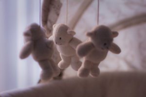 teddy bears hanging over crib